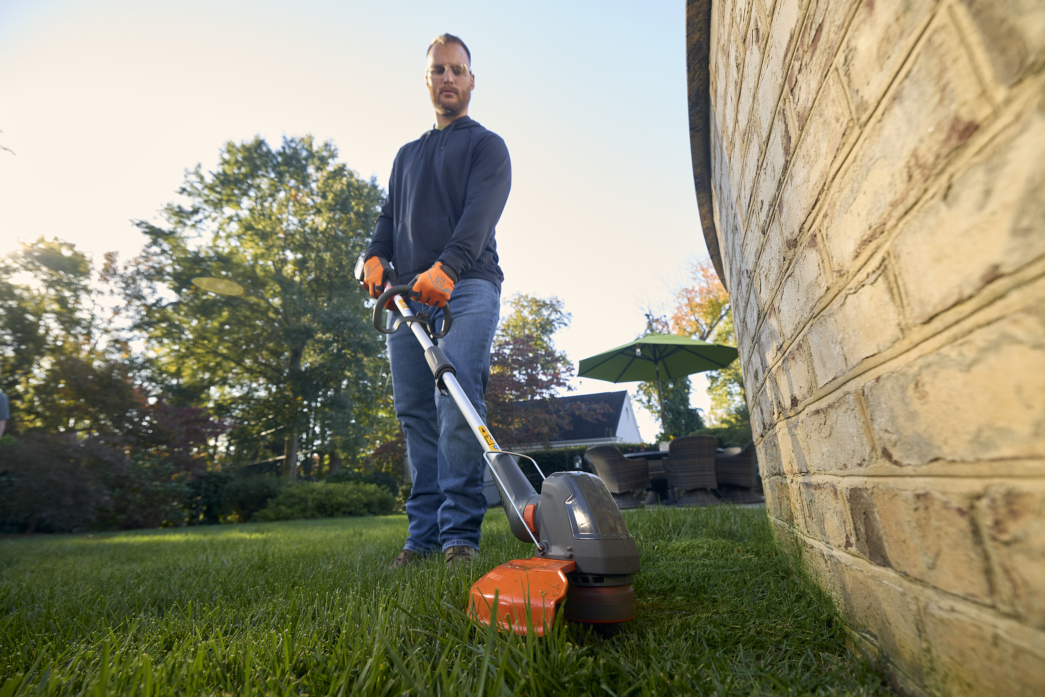man holding polesaw whilst cutting tree